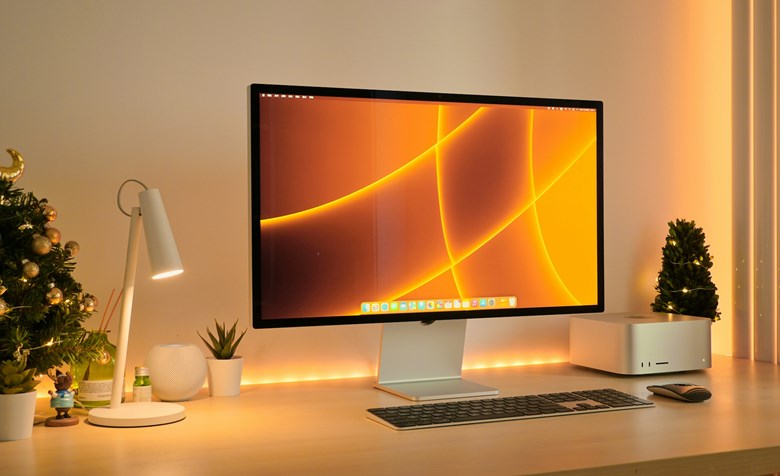 Workstation com um monitor grande e periféricos sem fios, com uma decoração minimalista e moderna.