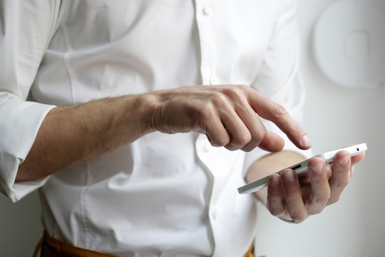 Homem de camisa branca a trabalhar no seu smartphone