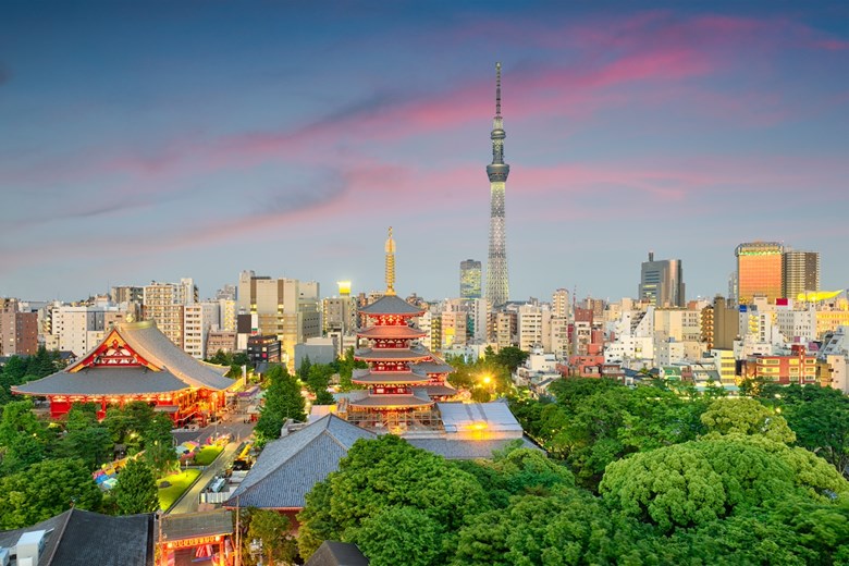 A linha do horizonte de Tóquio ao anoitecer, com a icónica torre Tokyo Skytree e o templo budisya Senso-ji, em Asakusa